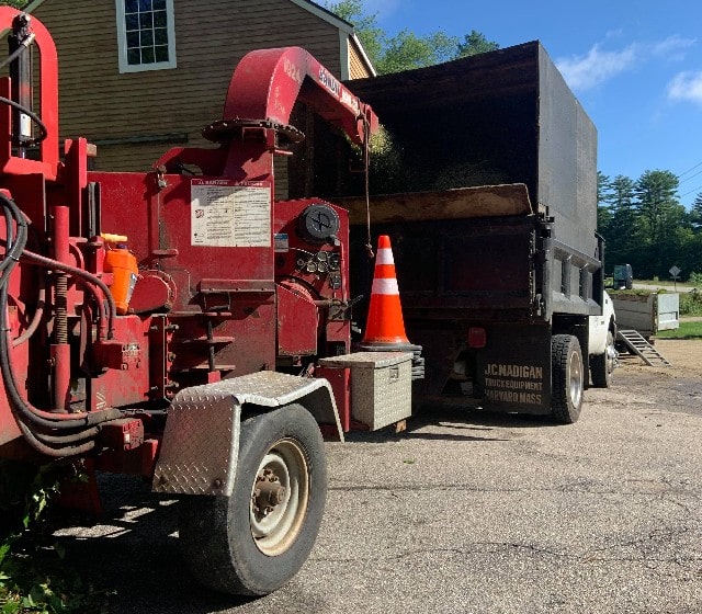 Brush chipper converting tree branches into wood chips